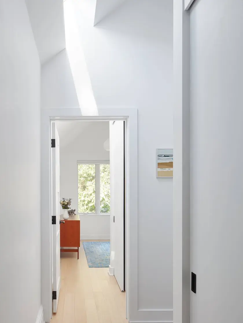 a hallway with a skylight facing a bedroom