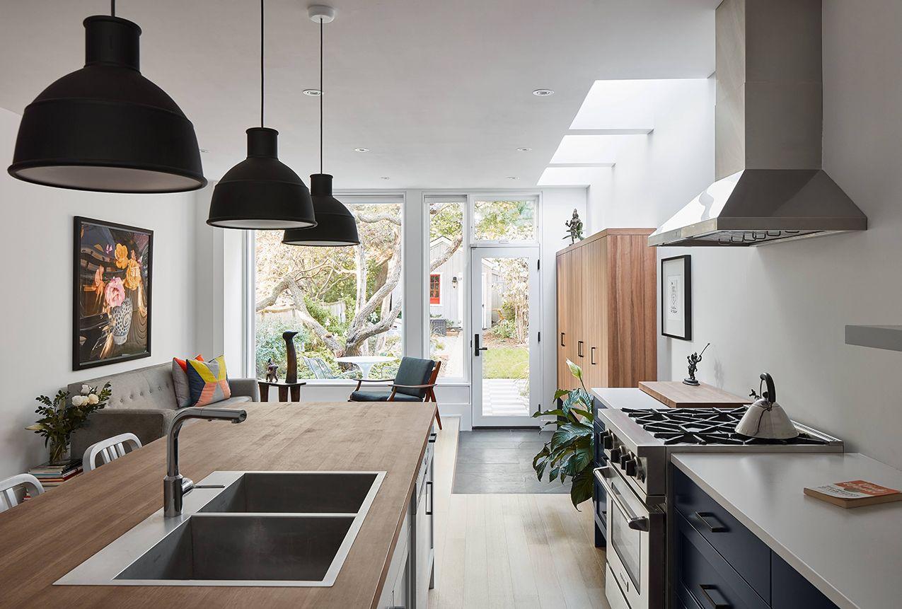 wide view of the kitchen with an island, large windows, and custom millwork facing the backyard